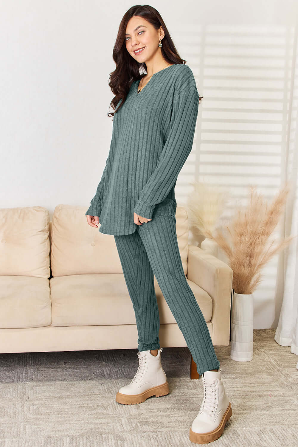 Woman wearing notched long sleeve top and pants set, ribbed texture, basic style, in living room setting