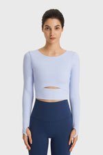 Model wearing a light blue Millennia Cutout Long Sleeve Cropped Sports Top, perfect for yoga and stylish workouts.