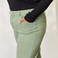 Woman modeling Risen Jeans in pastel green, showcasing wide-leg design and stylish pockets. Perfect for casual and dressed-up looks.