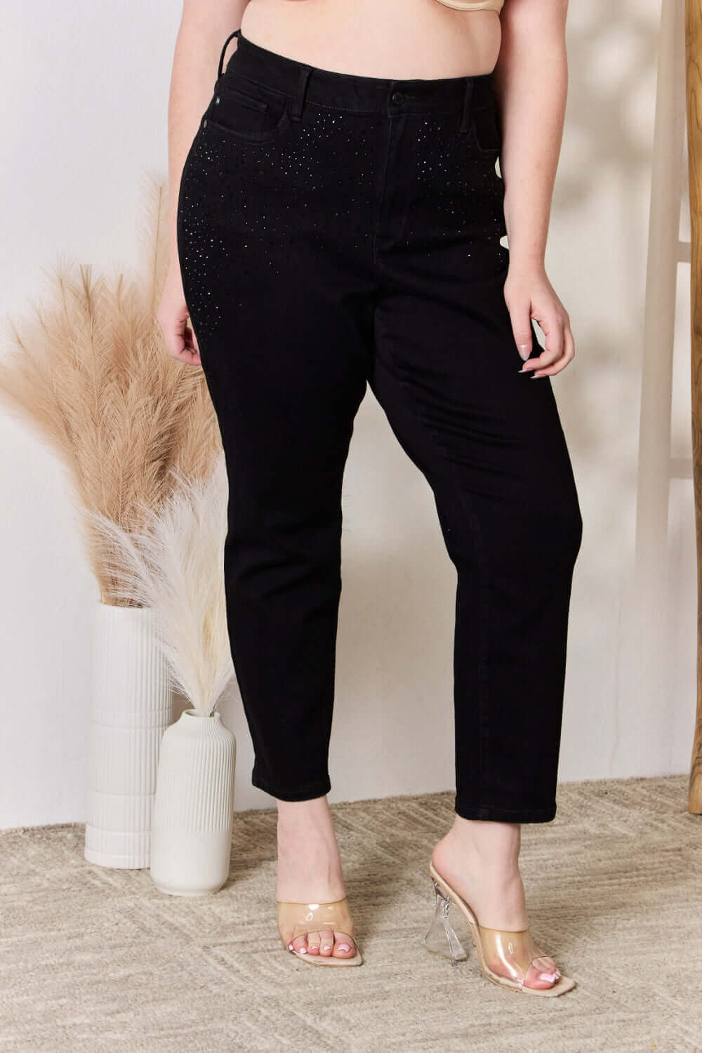 Woman wearing Judy Blue rhinestone embellished slim jeans with high waist, slightly stretchy fit, and pocketed design in black.