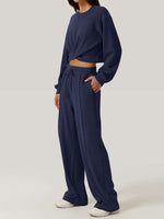 Woman in Bella Road Crisscross Round Neck Top and Drawstring Pants Set, 100% polyester, stylish and comfortable, perfect for casual outings.