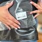 Woman holding packaged RFM Full Size High Rise Tummy Control Wide Leg Jeans in plastic wrap