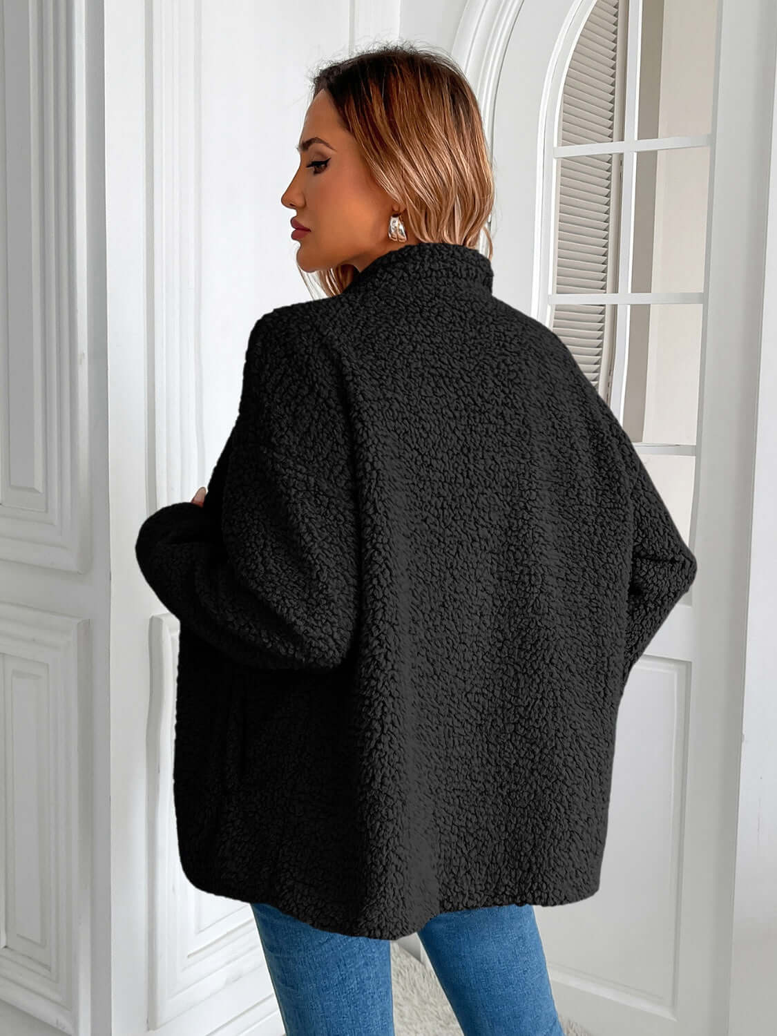 Woman wearing Ivy Lane Zip Up Long Sleeve Fuzzy Jacket in black, cozy and stylish for chilly days. Back view.