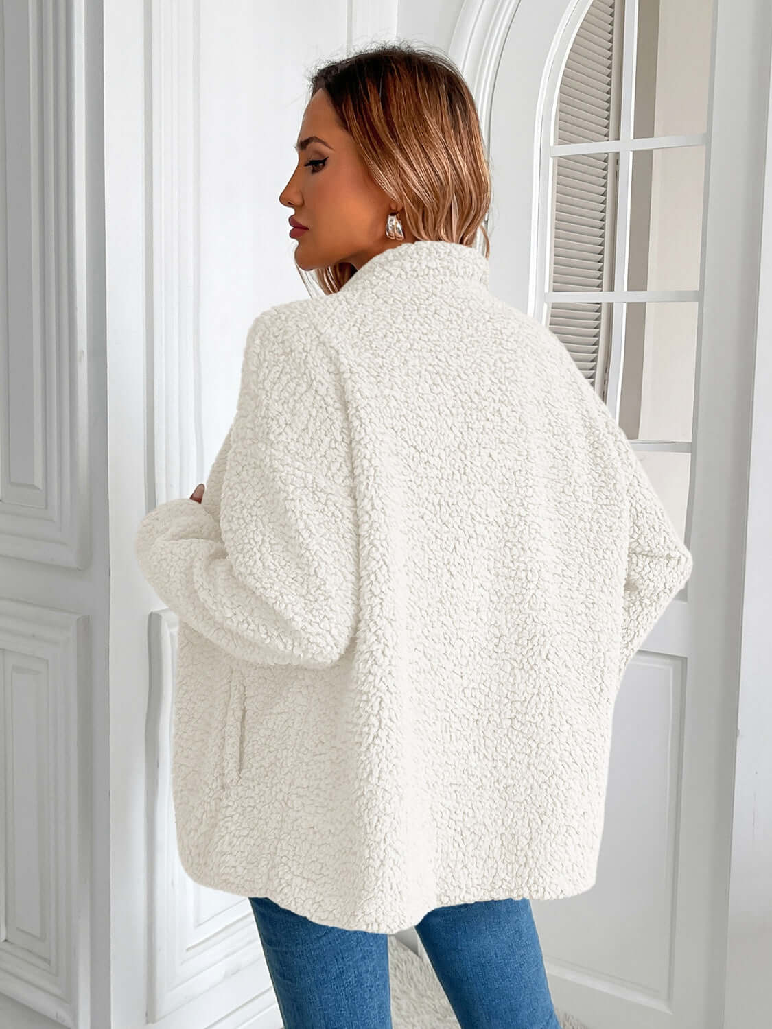 Woman wearing Ivy Lane Zip Up Long Sleeve Fuzzy Jacket in white, showcasing cozy texture and style from the back view.