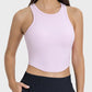 Millennia round neck racerback active tank in soft pink, featuring a sleek design and moderate stretch for comfort.