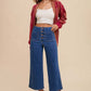 Woman wearing Annie Wear button fly high waist jeans with a crop top and cardigan, showcasing a chic retro-inspired look.