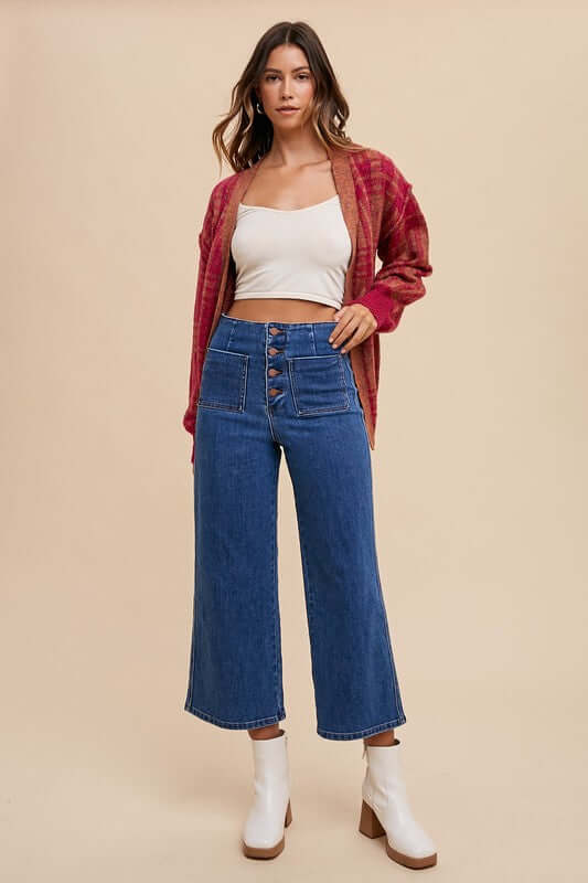 Woman wearing Annie Wear button fly high waist jeans with a crop top and cardigan, showcasing a chic retro-inspired look.