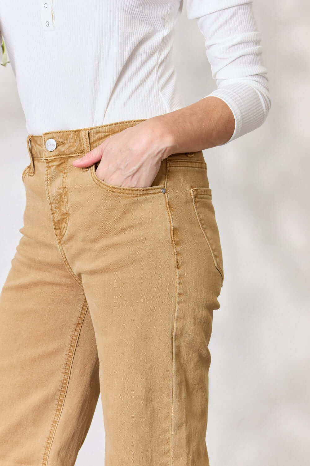 Woman wearing Risen jeans with wide-leg design and pocketed detail in a trendy beige color.