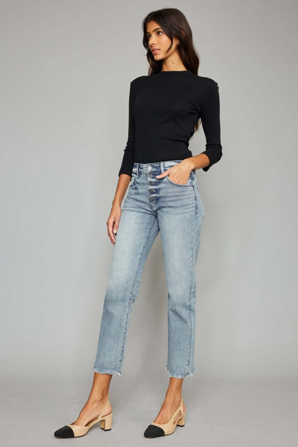 Model wearing High Waist Button Fly Raw Hem Cropped Straight Jeans with a black top and beige heels