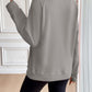 Ivy Lane Half Zip Raglan Sleeve Sweatshirt in grey, back view. 100% polyester, pocketed, opaque, machine washable. Model wearing black shorts.