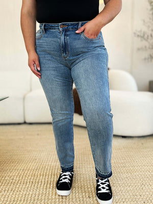 Woman wearing Full Size Mid Rise Rigid Magic Release Hem Jeans by Judy Blue Jeans, showcasing stylish and versatile denim for any occasion.