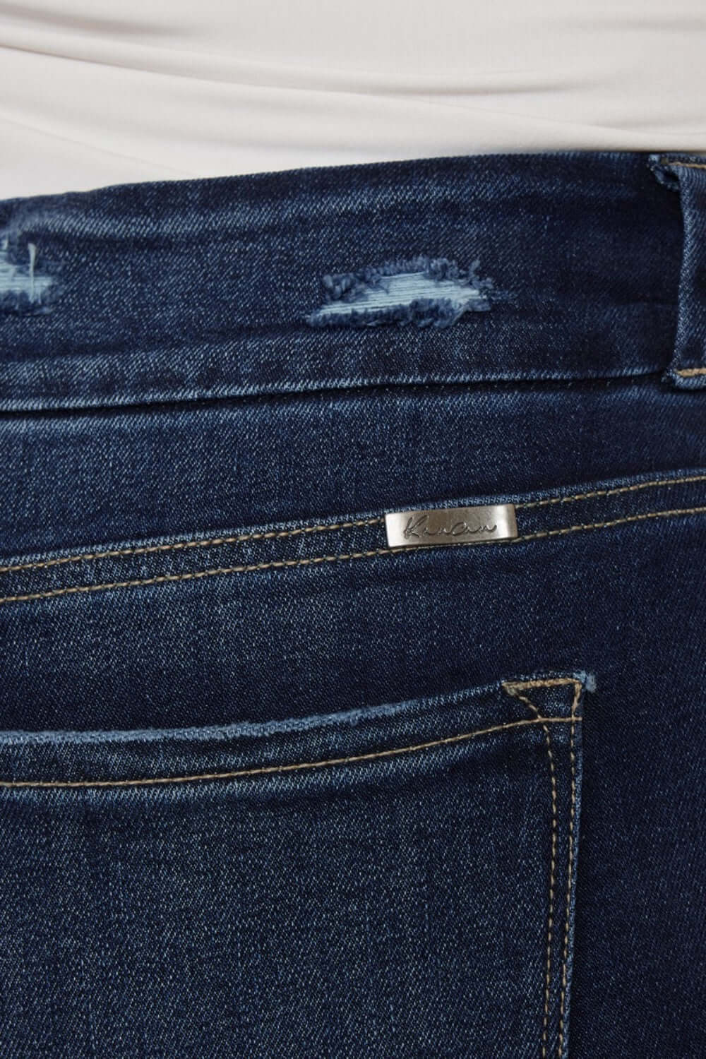 Close-up of Cat's Whiskers Raw Hem High Waist Jeans showcasing raw hem detail and back pocket.