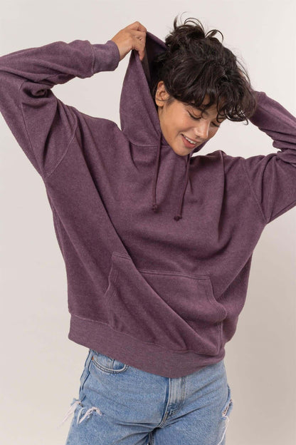 Cozy woman in a purple brushed long sleeve hoodie with kangaroo pocket, perfect for casual outings and lounging.