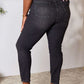 Woman wearing Judy Blue tummy control high waist denim jeans in black, showcasing back pockets and slightly stretchy fit. Full size.