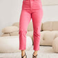 Pink high-waisted raw hem jeans with tummy control worn by model with black heels, showcasing comfortable and stylish RFM Jeans