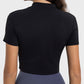 Model showcasing the back view of a black Millennia Quarter Zip Short Sleeve Active T-Shirt, perfect for workouts.