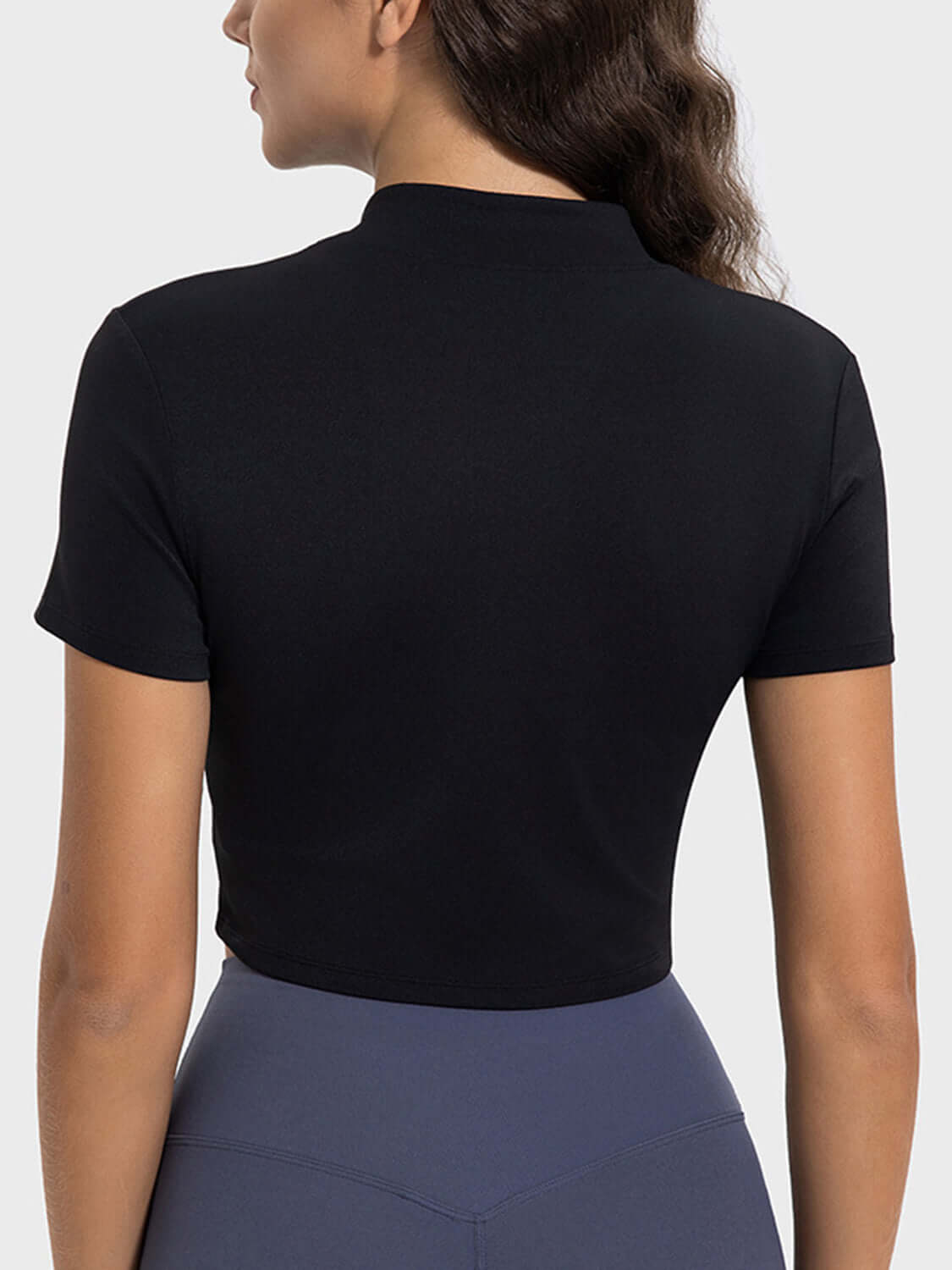 Model showcasing the back view of a black Millennia Quarter Zip Short Sleeve Active T-Shirt, perfect for workouts.