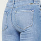 Close-up of Distressed Cat's Whiskers Button Fly Jeans, showcasing the back pocket and light blue denim with a trendy worn-in look.