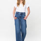 Woman wearing Judy Blue double button wide leg jeans, featuring a high rise and moderate stretch, paired with a white blouse.