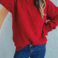 Bella Road Diamond Round Neck Long Sleeve Sweater in red, featuring a unique diamond pattern, worn with blue jeans for a stylish look.