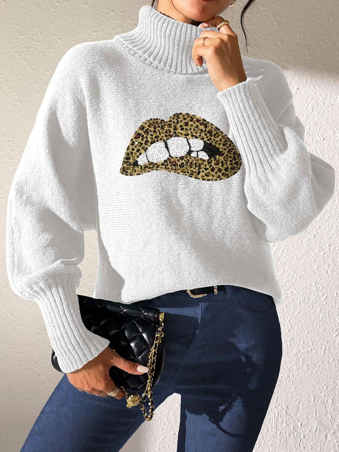 Woman wearing Bella Road Lip Turtleneck Long Sleeve Sweater in white, featuring a leopard print lip design, paired with dark jeans.