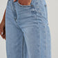 Close-up of Bella Road Raw Hem Wide Leg Jeans with Pockets in light blue denim fabric, showcasing front pockets and high-waist design.