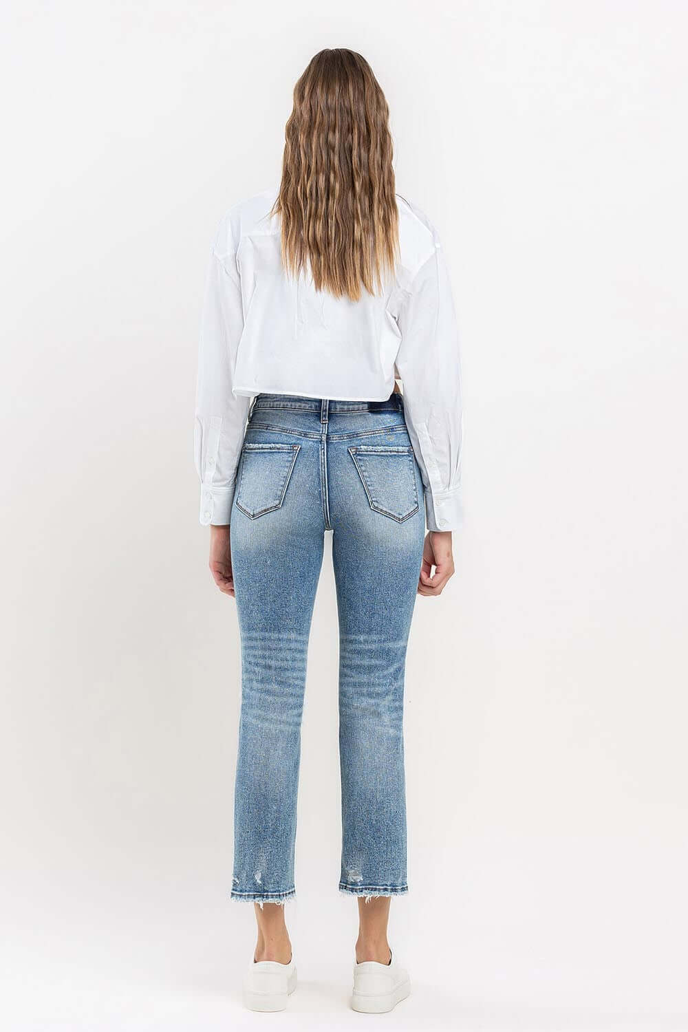 Woman wearing Lovervet Full Size High Rise Slim Straight Jeans, back view showing flattering high-rise fit and slim straight leg style