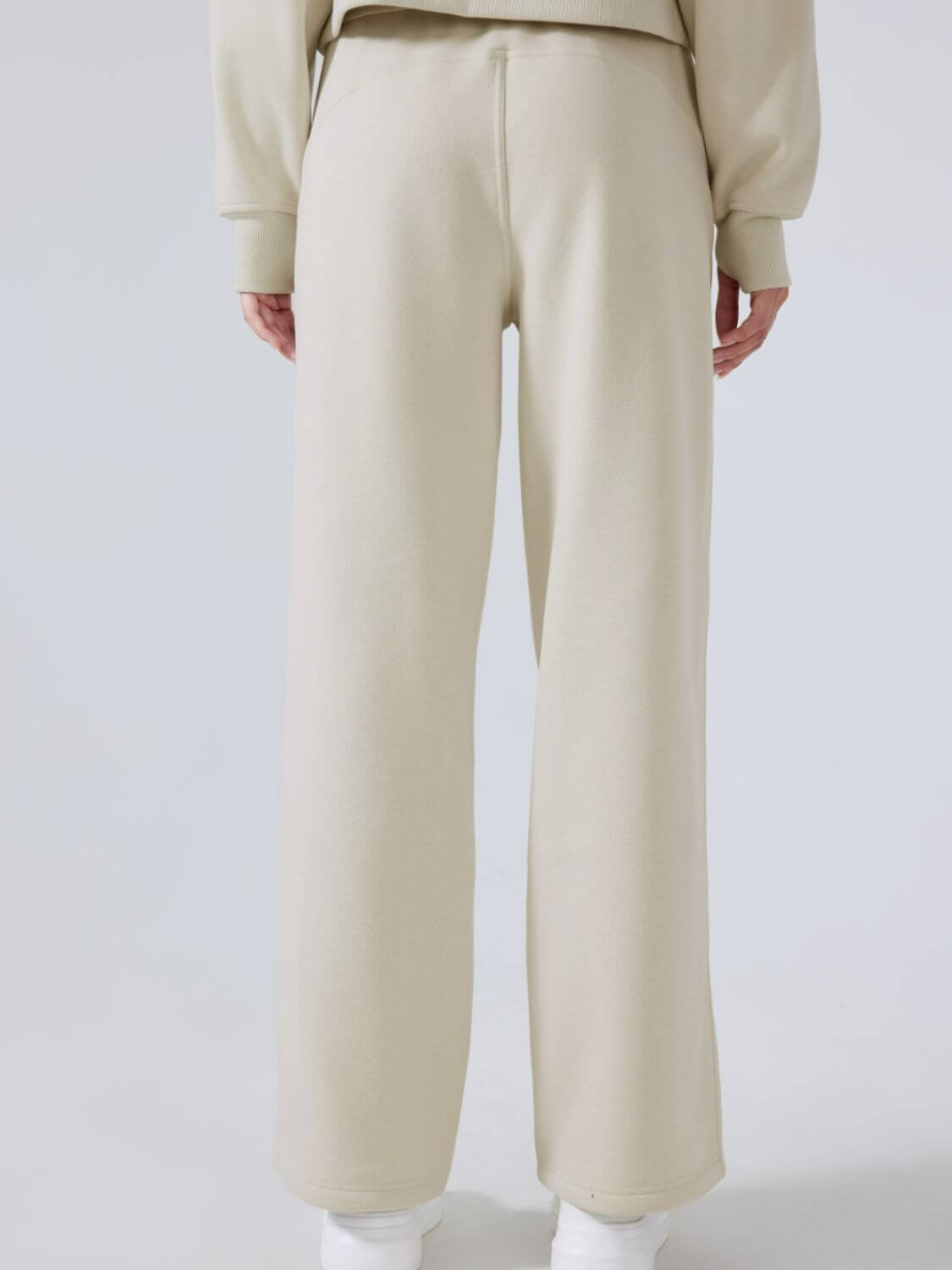 Back view of Millennia Drawstring Wide Leg Pants in beige, showcasing the comfortable fit and stylish wide leg design.