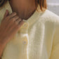 Close-up of a woman in a pastel yellow Bella Road Button Down Cardigan with button details, perfect for cozy days.