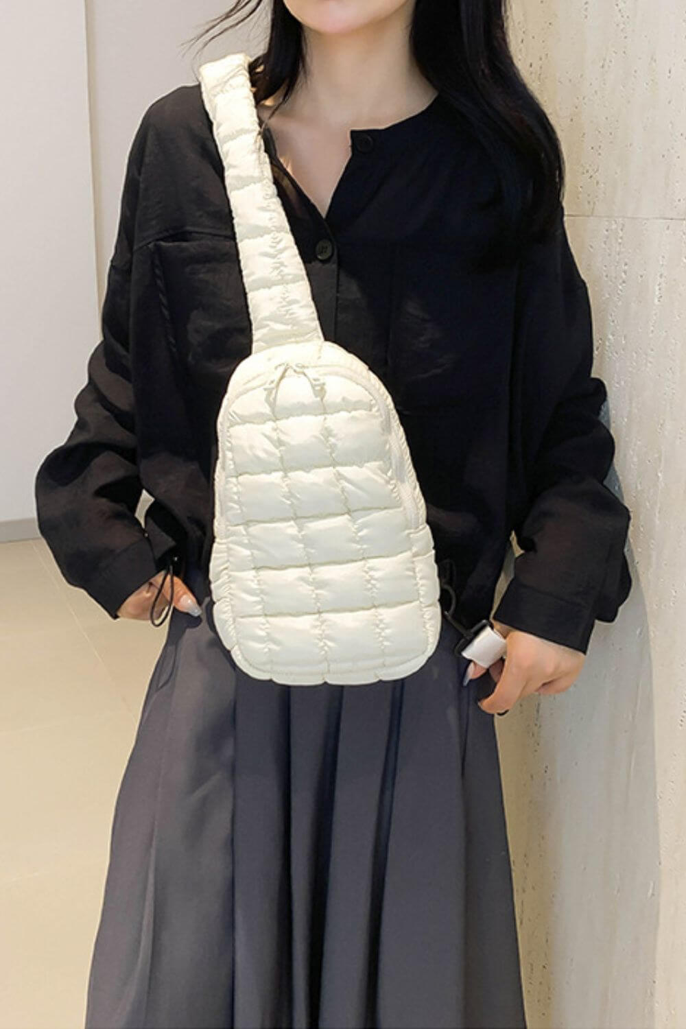 Trendy white quilted nylon crossbody bag in medium size worn by woman in stylish outfit.