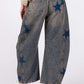 Rear view of SAGE + FIG Star Wide Leg Jeans featuring blue star patterns and functional pockets, styled with a cozy sweater.