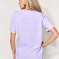 Woman wearing a purple graphic round neck short sleeve t-shirt, full size, back view.