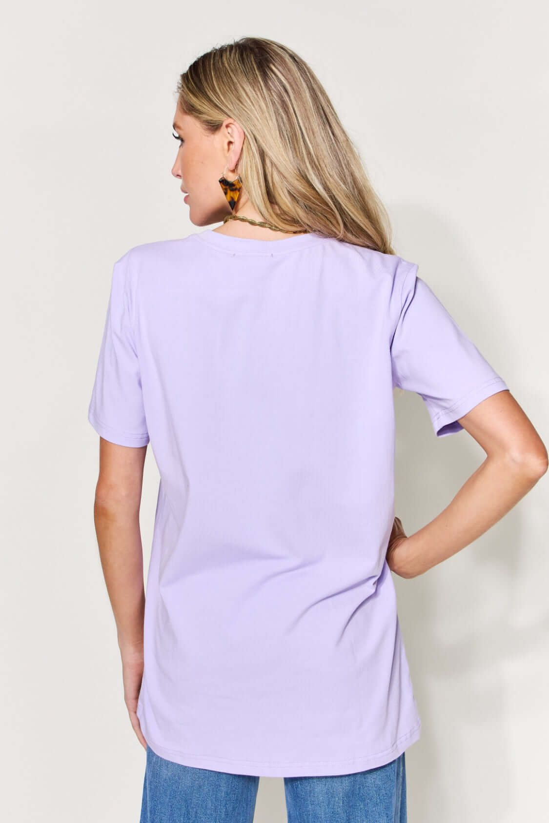 Woman wearing a purple graphic round neck short sleeve t-shirt, full size, back view.