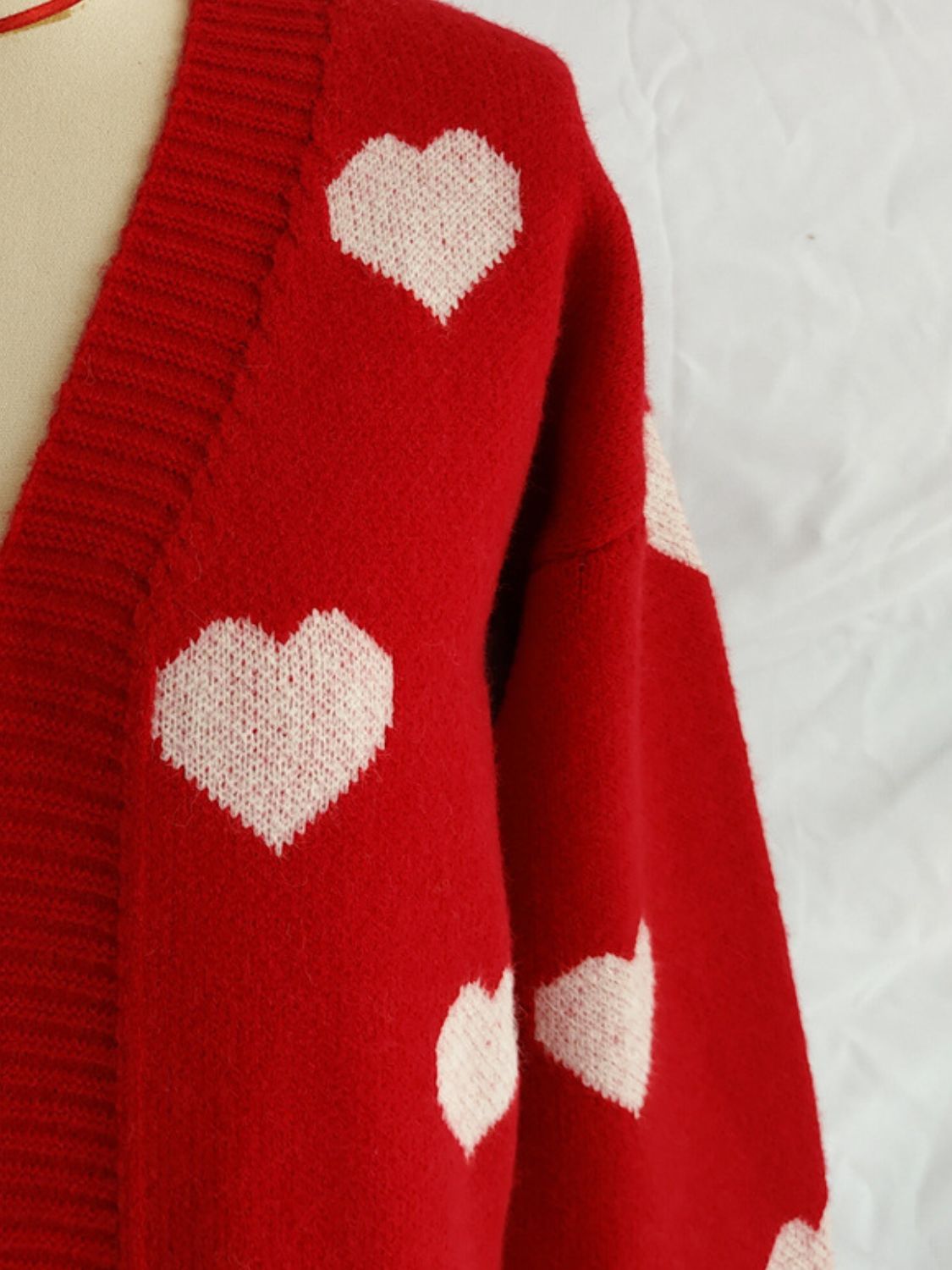 Close-up of Bella Road Heart Open Front Long Sleeve Cardigan in red with white heart patterns.