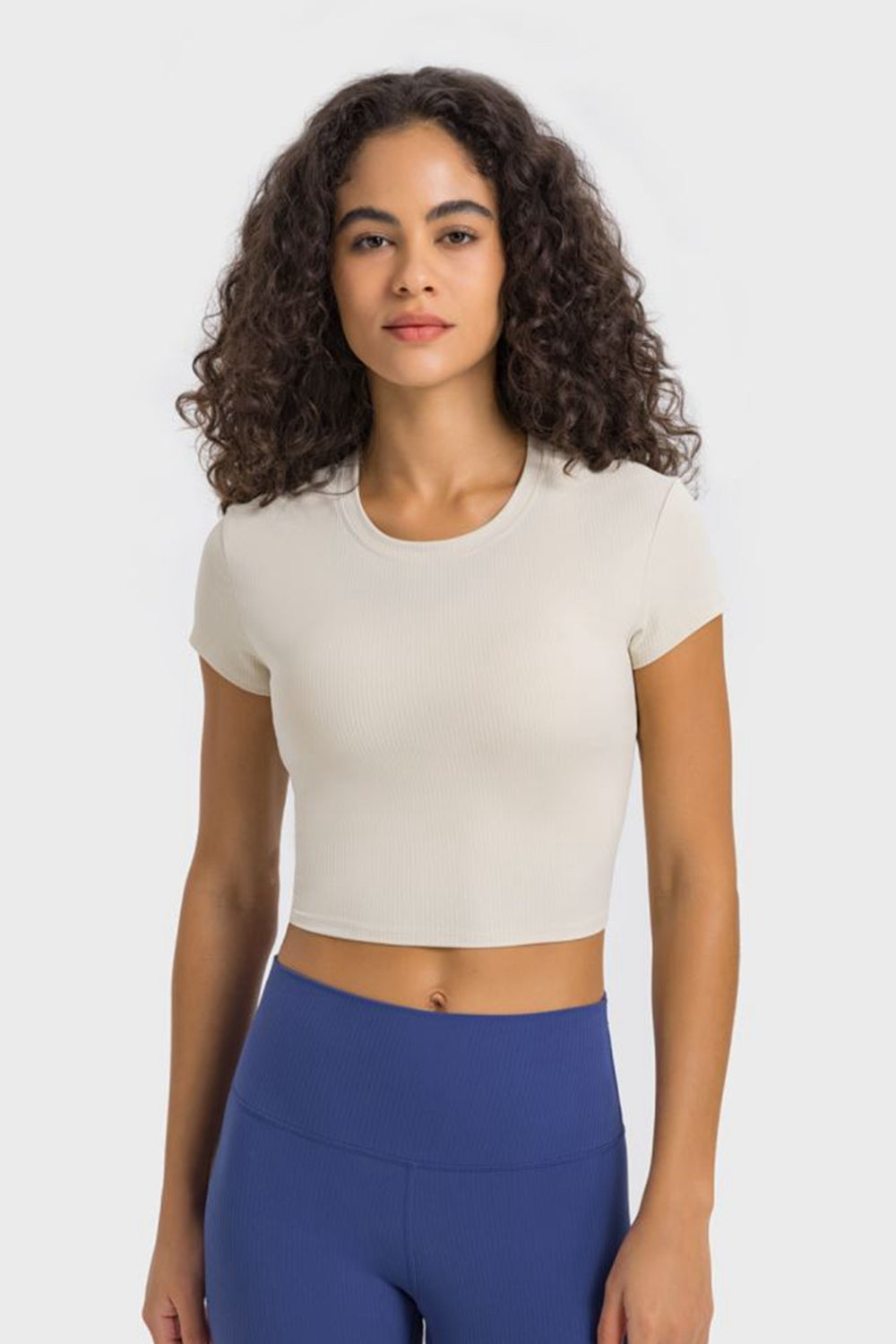 Millennia cropped sports t-shirt in cream, featuring round neck and short sleeves, perfect for yoga and fitness activities.