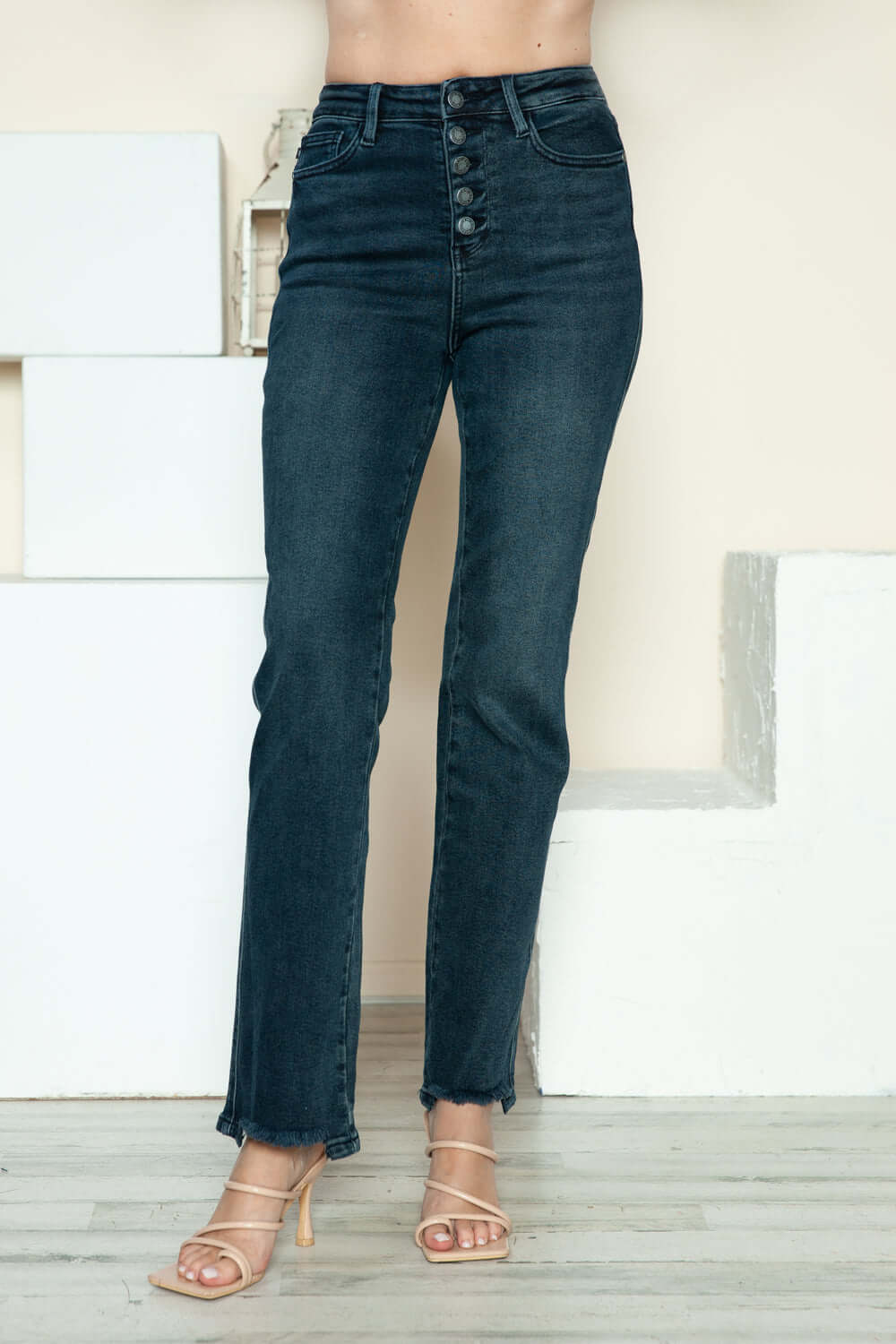 Judy Blue button fly hem destroy jeans showcasing trendy distressed details against a stylish backdrop.