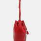 Nicole Lee USA Amy Studded Bucket Bag in red vegan leather, side view showing drawstring closure and stud detailing.