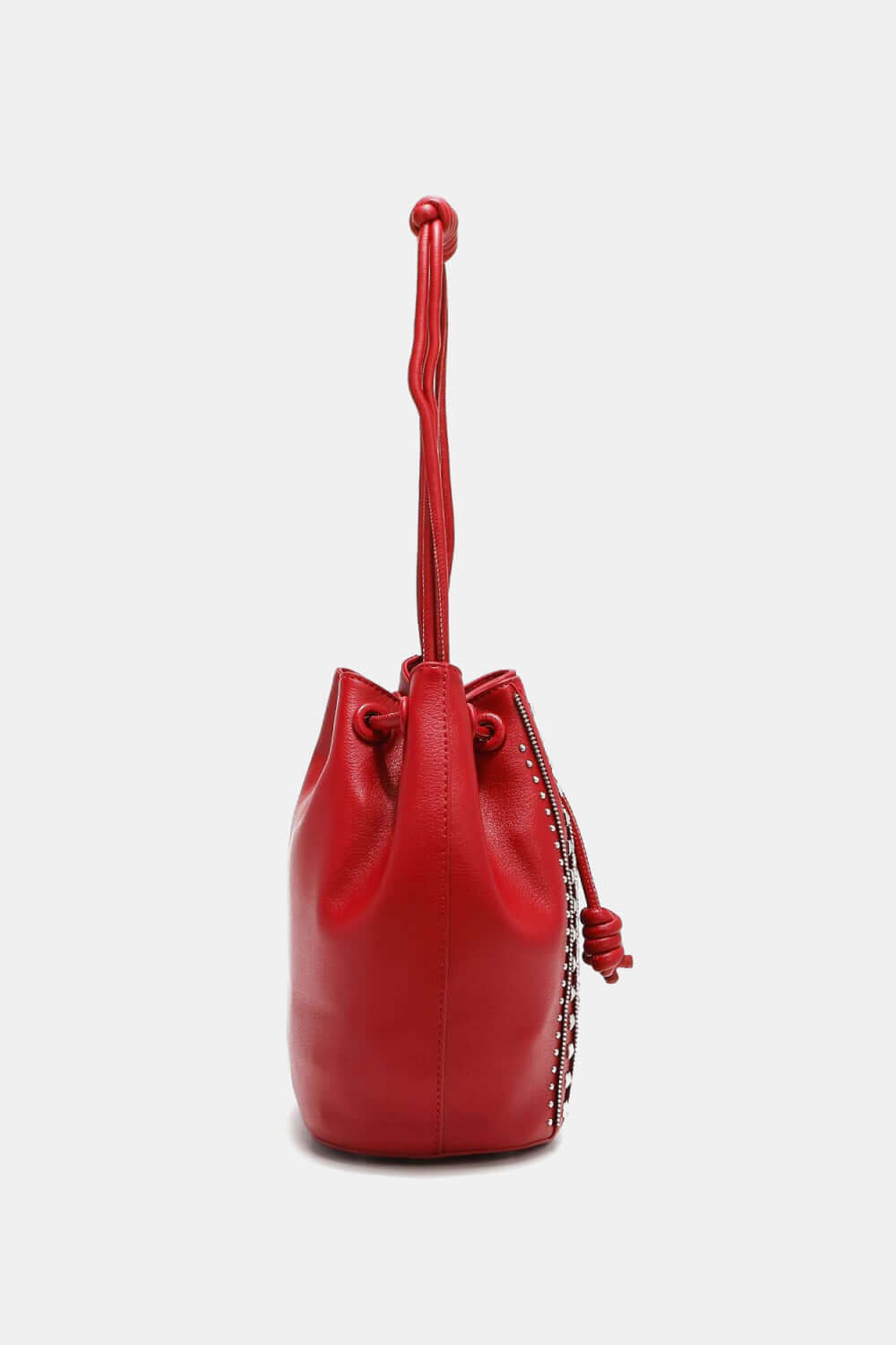 Nicole Lee USA Amy Studded Bucket Bag in red vegan leather, side view showing drawstring closure and stud detailing.