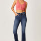 Woman wearing Risen Jeans frayed hem cropped straight jeans paired with a coral crop top and clear heels for a chic casual look.