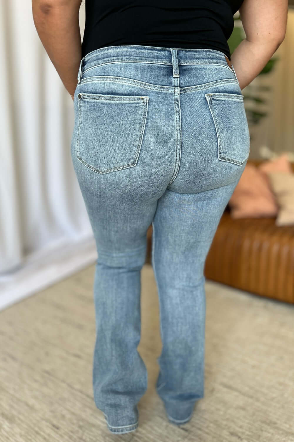 Woman wearing Judy Blue medium rise bootcut jeans showing back view with a flattering fit and classic design.