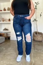 Woman wearing Judy Blue High Waist Rigid Magic Heavy Destroy Straight Jeans with heavy distressing and a flattering high waist design