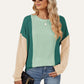 Trendy woman in Double Take Texture Contrast Round Neck Long Sleeve T-Shirt in green combo, accessorized with sunglasses and a handbag.