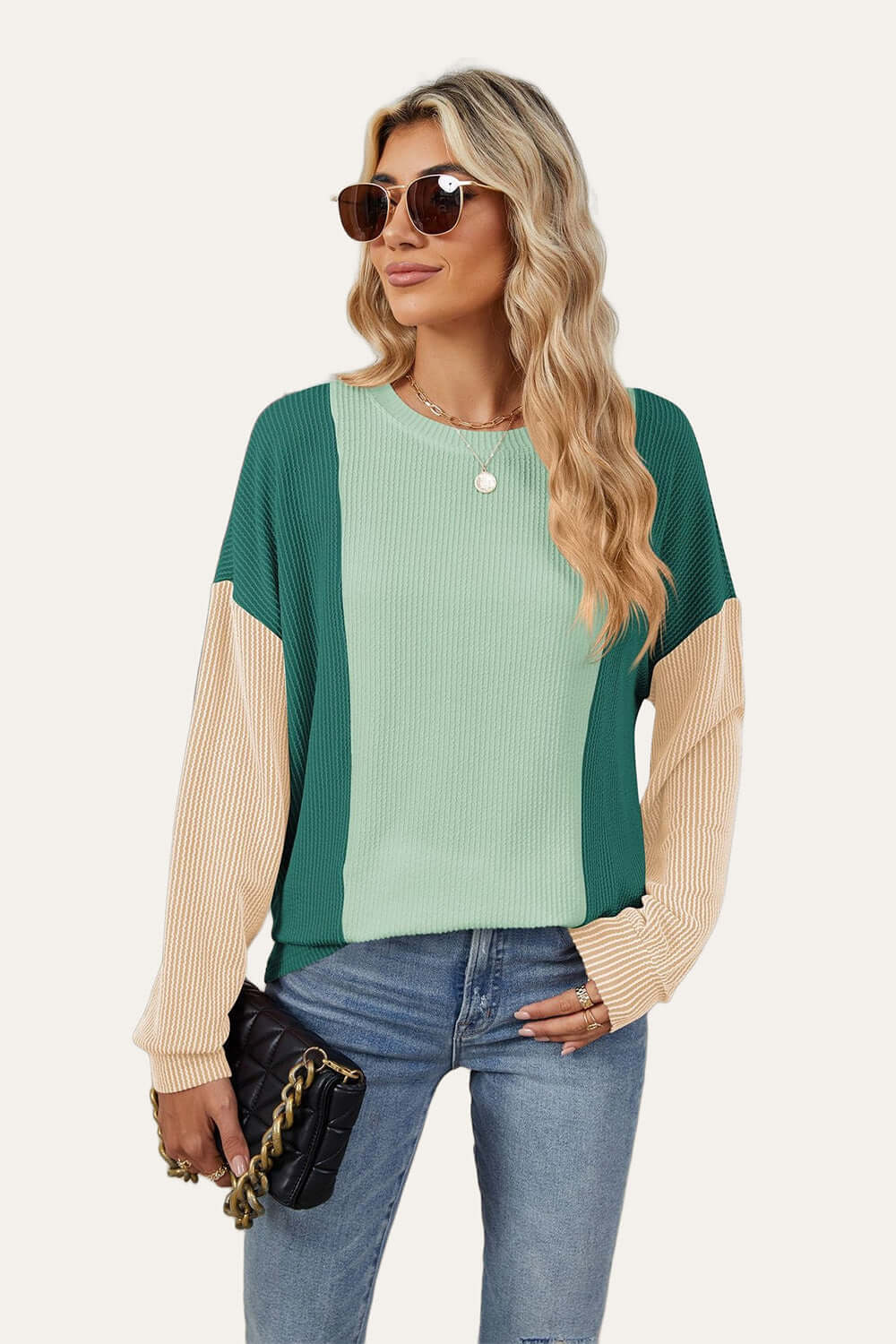 Trendy woman in Double Take Texture Contrast Round Neck Long Sleeve T-Shirt in green combo, accessorized with sunglasses and a handbag.