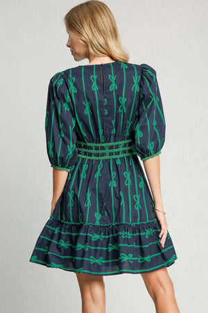 Back view of Umgee Ribbon Print Frill Contrast Velvet Trim Half Sleeve Dress with green bow design and flared skirt.