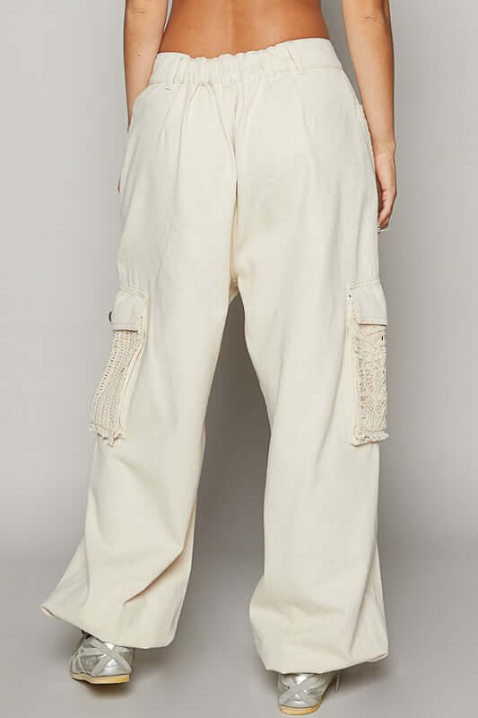 Back view of cream cargo pants with crochet patches, showcasing a relaxed fit and trendy style.