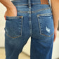 Back view of Mid Rise Distressed Raw Hem Judy Blue Jeans with worn-in detailing and raw edges for an edgy look