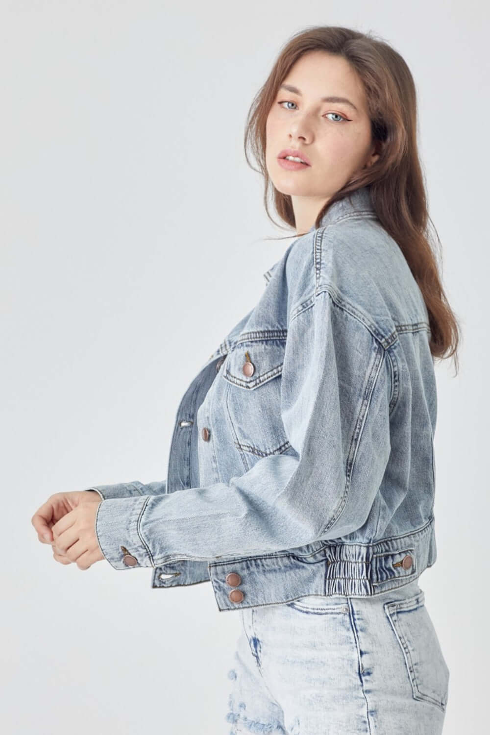 Woman wearing RISEN full size button down cropped denim jacket with casual chic style.