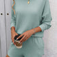 Woman wearing mint green Double Take Round Neck Long Sleeve Top and Shorts Set, holding coffee, perfect for casual outings or lounging.