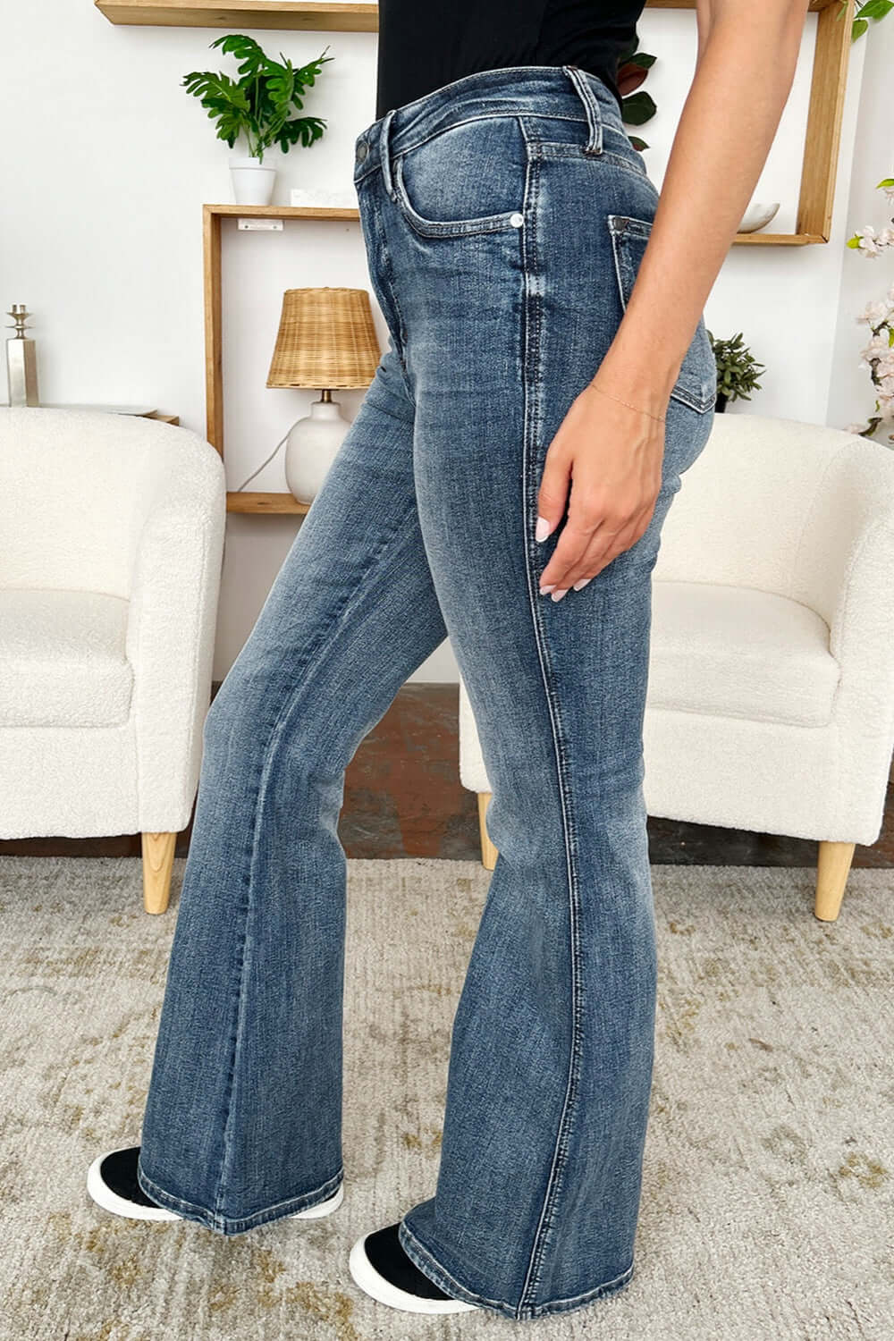 High Waist Tummy Control Flare Jeans by Judy Blue Jeans, side view showing sleek silhouette and retro flare leg in casual indoor setting