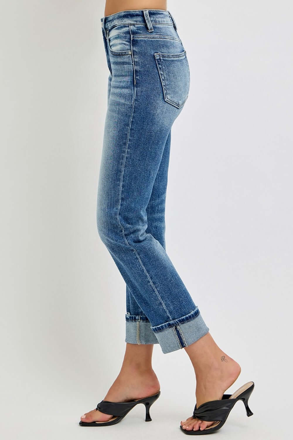 High-rise cropped straight roll-up jeans, versatile for any occasion, shown with rolled hem on model, side profile view.